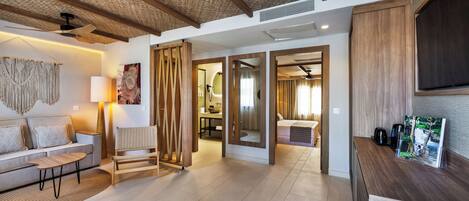 A modern hotel lobby with a sofa, a coffee machine, and a wooden reception desk.
