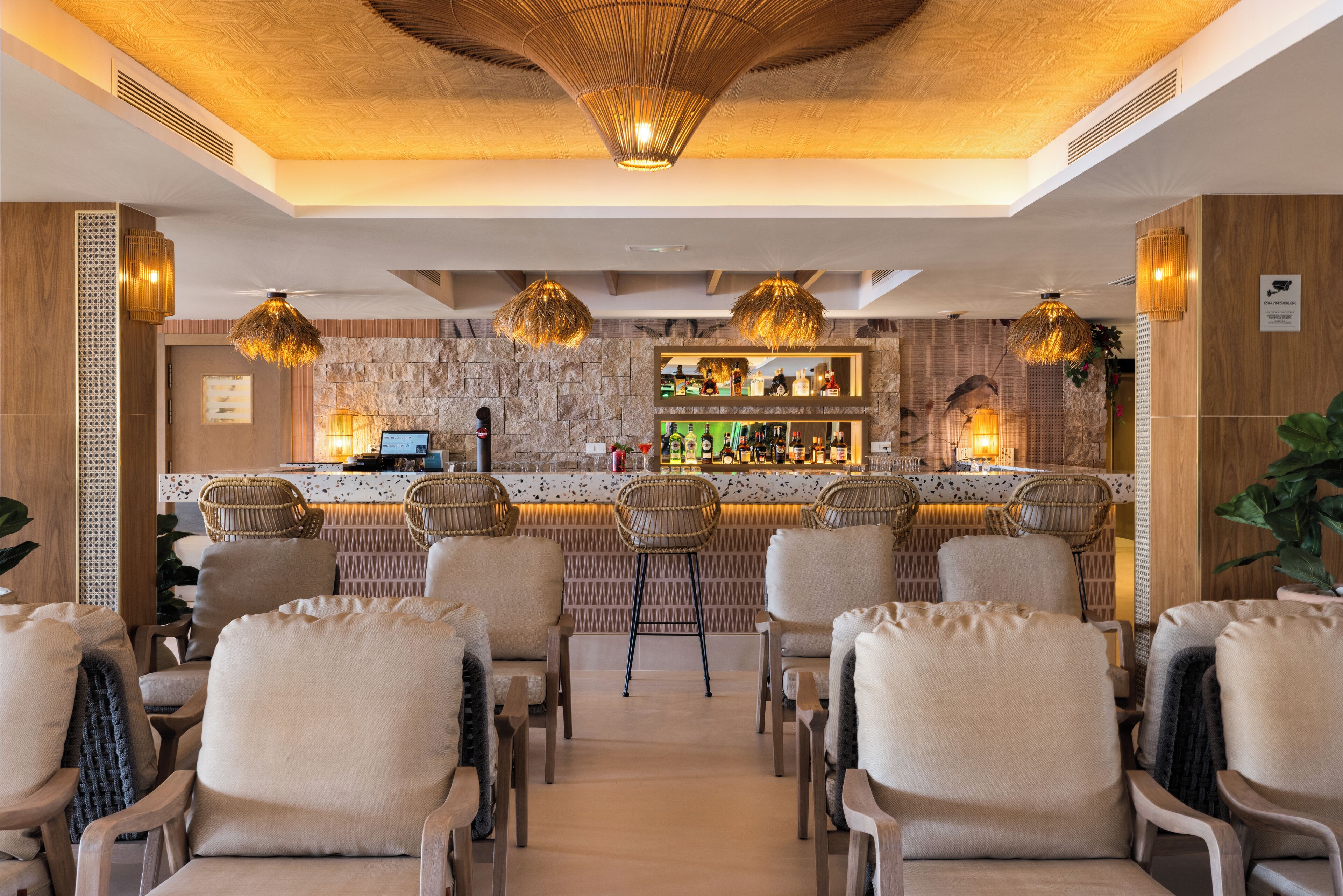 Eine Bar mit Korbstühlen und einer Theke.