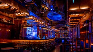 Eine Bar mit modernem Industriedesign, die freiliegende Rohre und eine zentrale runde Leuchte zeigt.