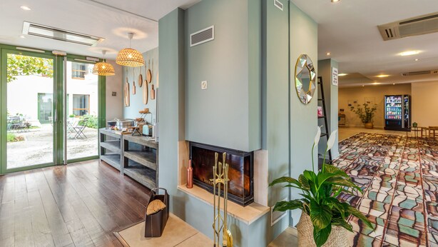 Una sala moderna con chimenea, un comedor con mesa y sillas, y un suelo estampado.