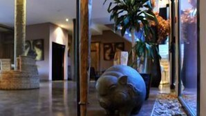 A lobby with a statue, a large potted plant, and a decorative animal sculpture. - Hôtel restaurant spa Disini Montpellier Est, The Originals Relais (Castries)