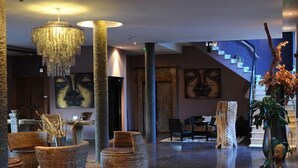 A spacious lobby with a modern chandelier, wicker furniture, and a staircase leading to upper floors. - Hôtel restaurant spa Disini Montpellier Est, The Originals Relais (Castries)