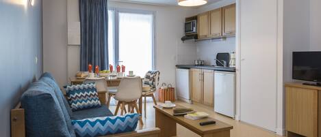 Un apartamento moderno con sala de estar, comedor y cocina.