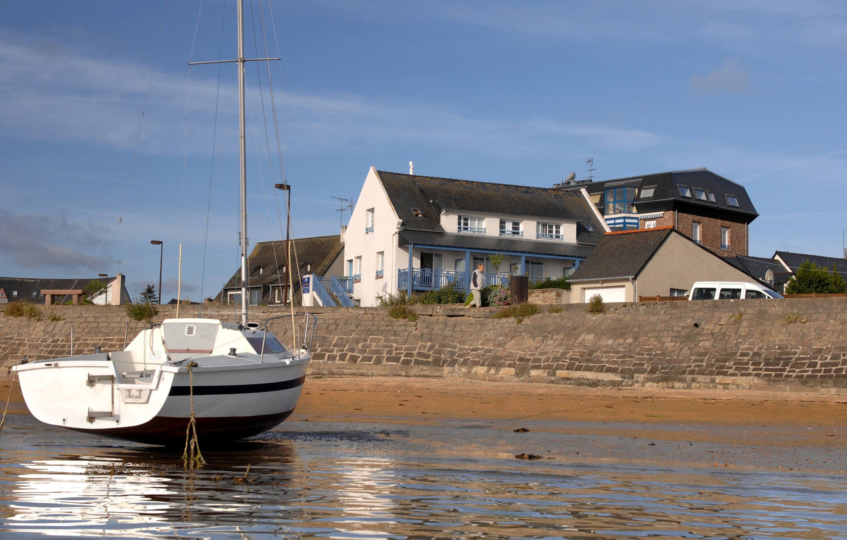 A boat moored near a waterfront with a building in the background.