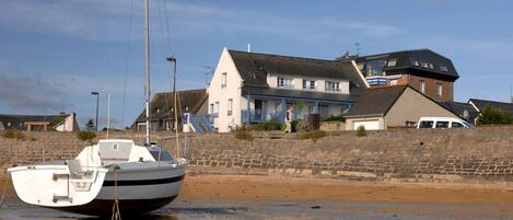 A boat moored near a waterfront with a building in the background.