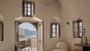 Una habitación con vista a un cuerpo de agua, un comedor con sillas, un sofá y un aparador de madera.