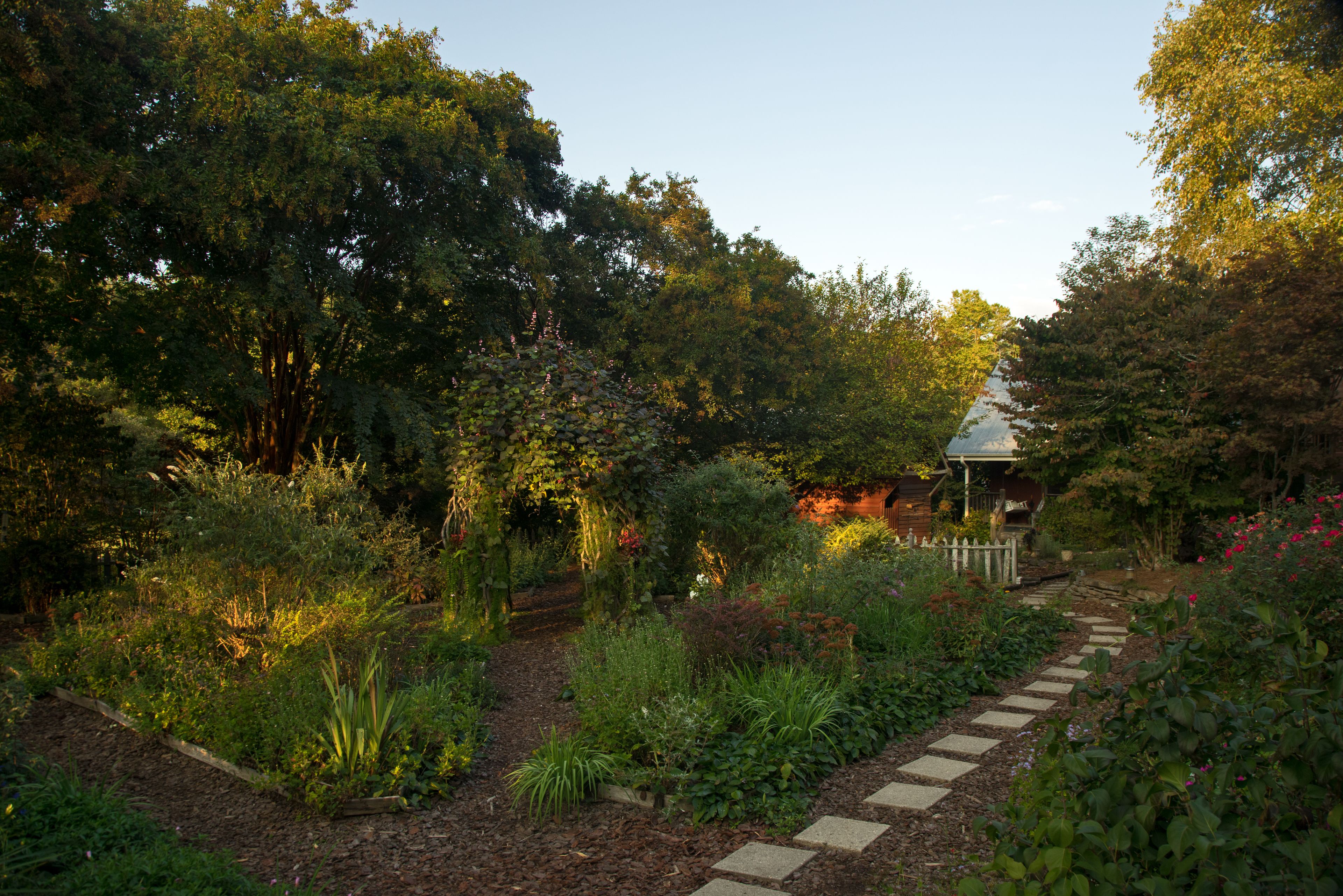 A garden with a stone pathway leading to a gazebo.