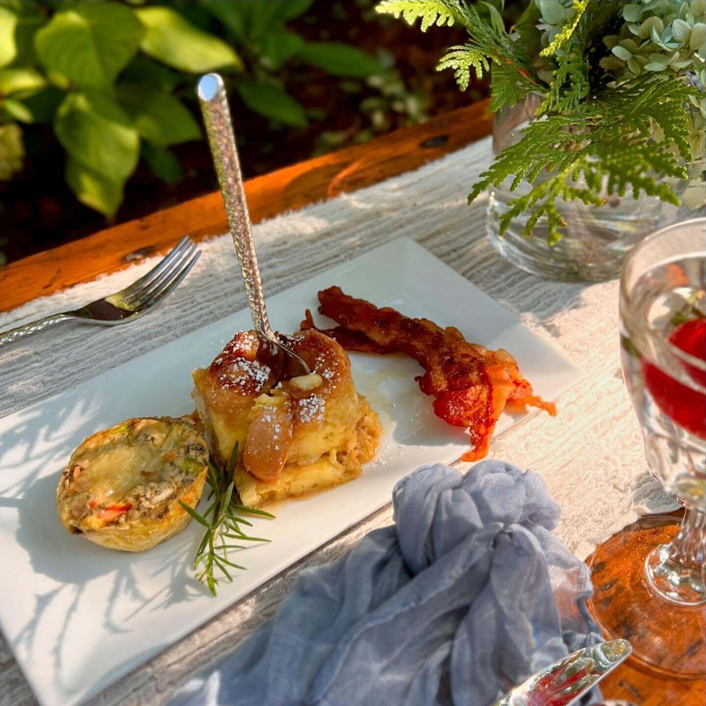 A meal with a fork, a glass, and a napkin on a table.