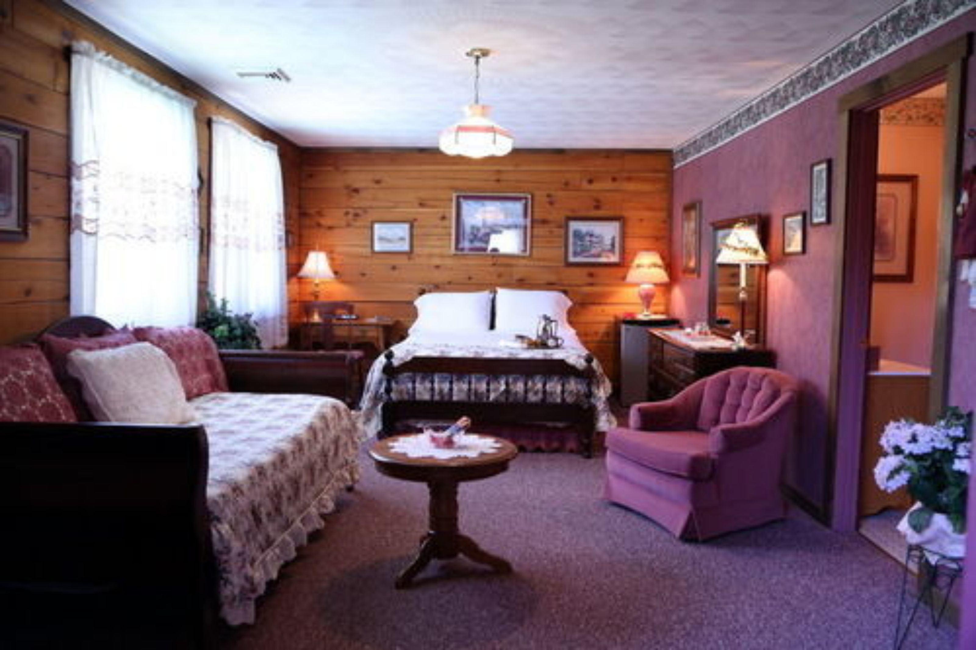 Een gezellige kamer met een bed, een bank, een stoel en een kleine tafel.