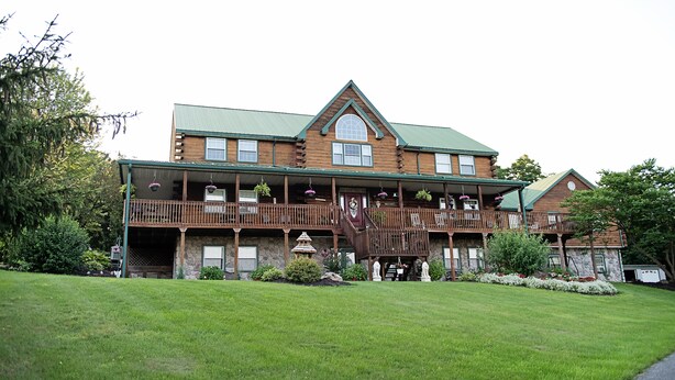 A large, two-story lodge with a prominent balcony and a stone facade.