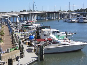A marina with boats docked, a pedestrian walkway, and a bridge in the background. - The Magnolia House Inn (Hampton)