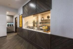A modern kitchen area with a buffet setup, including glass display cases and a fresh meal sign. - Hilton Garden Inn Lynchburg (Lynchburg)