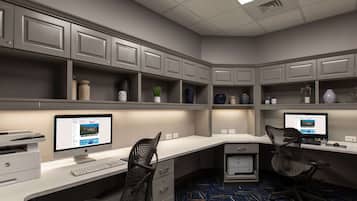 A modern office space with two desks, each with a computer and printer, and a chair.