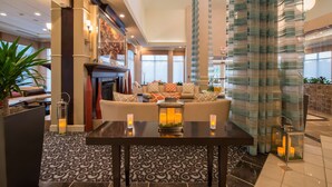 A spacious lobby with a sofa set, a fireplace, and a patterned floor.