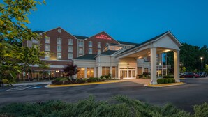 A Hilton Garden Inn with a brick facade, a covered entrance, and a parking lot.