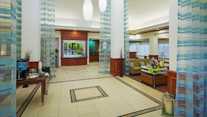A spacious lobby with a coffee station, seating area, and a large window with a view. - Hilton Garden Inn Austin North (Austin)