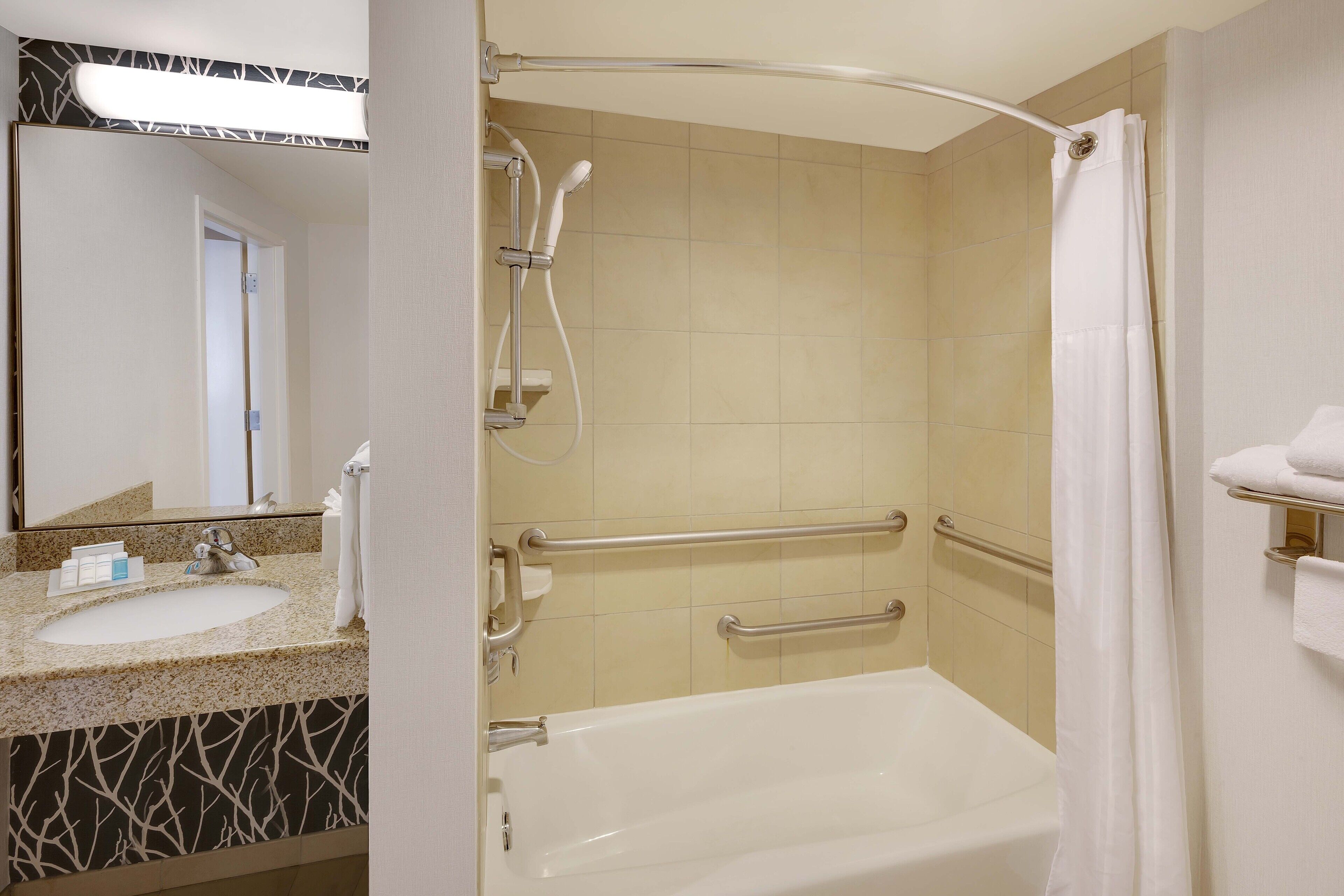 Une salle de bain équipée d’une baignoire, d’une douche et d’un lavabo avec un porte-serviettes.