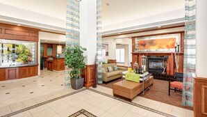 A spacious lobby with a fireplace, a seating area, and a reception desk. - Hilton Garden Inn Austin North (Austin)
