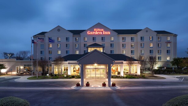 A Hilton Garden Inn with a large entrance and a flagpole with the American flag. - Hilton Garden Inn Austin North (Austin)
