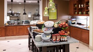 A breakfast buffet setup with various food items and beverages. - Hilton Garden Inn Austin North (Austin)