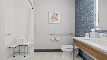 A modern bathroom with a shower, toilet, and sink.