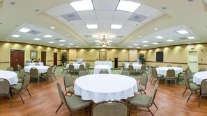 A conference room with round tables and chairs, a chandelier, and a carpeted floor. - Holiday Inn Express & Suites Millington by IHG (Millington)
