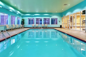 A swimming pool with clear water, surrounded by windows and chairs. - Holiday Inn Express & Suites Millington by IHG (Millington)