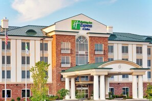 A Holiday Inn Express & Suites building with a brick facade, large windows, and a green roof. - Holiday Inn Express & Suites Millington by IHG (Millington)