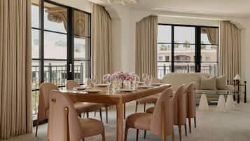 Un espace repas avec une longue table, plusieurs chaises et un canapé à l’arrière-plan.