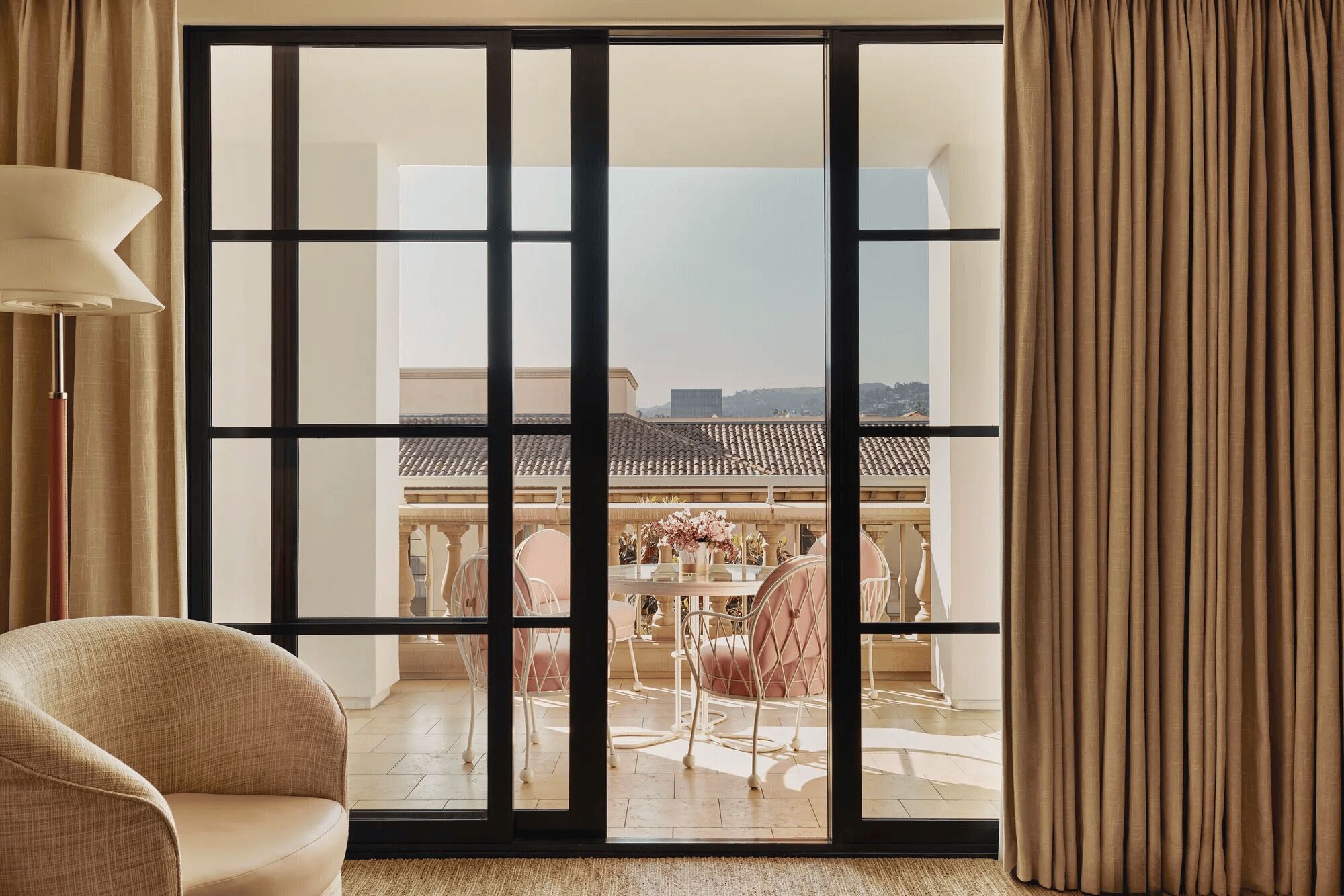 A room with a large sliding glass door leading to an outdoor dining area with a table and chairs.