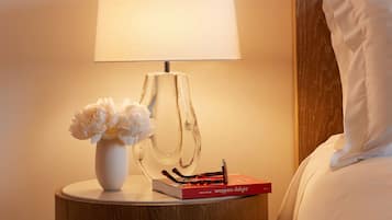 A bedside table with a lamp, a vase with flowers, and a book titled "Wrappers Delight" by Jerry Frank.