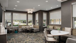 A modern lounge area with seating, a patterned carpet, and large windows offering a view of the outdoors. - Residence Inn by Marriott Birmingham/Hoover (Birmingham)