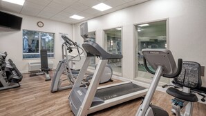 Un gimnasio con cintas de correr, una bicicleta estática y máquinas de pesas.