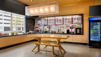 Ein modernes Schnellrestaurant mit Holztresen, Speisekarten und einer Mikrowelle, sowie einem Kühlschrank für Pepsi.