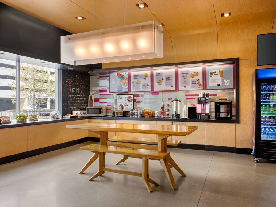 Ein modernes Schnellrestaurant mit Holztresen, Speisekarten und einer Mikrowelle, sowie einem Kühlschrank für Pepsi.