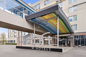 A modern hotel entrance with a distinctive awning and a large sign for 'W Hotels'.
