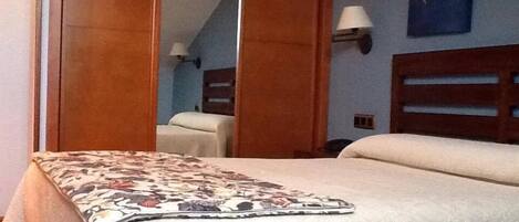 A hotel room with a bed, a nightstand, a lamp, and a painting on the wall.