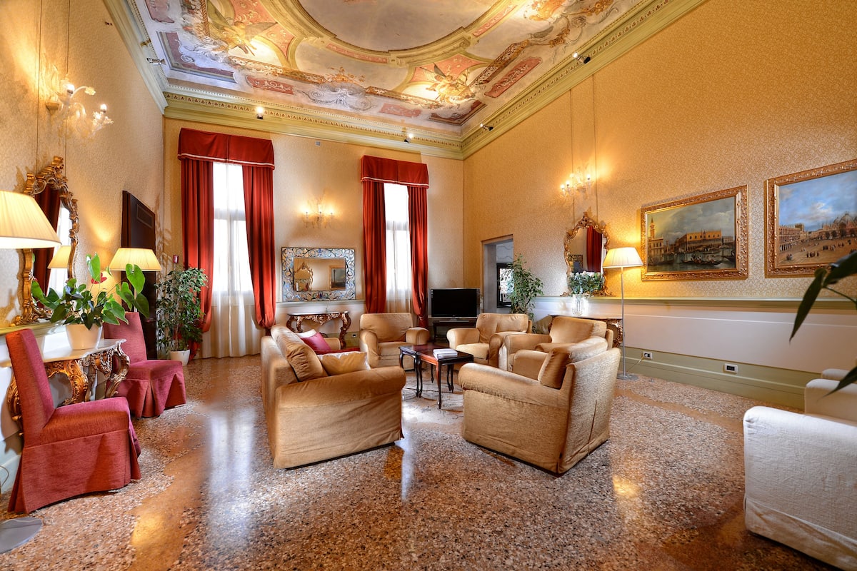 A spacious living room with a fireplace, comfortable seating, and a television.