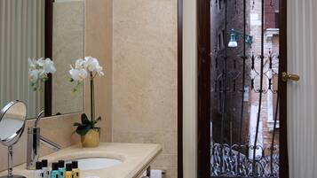 A bathroom with a sink, mirror, and toiletries.
