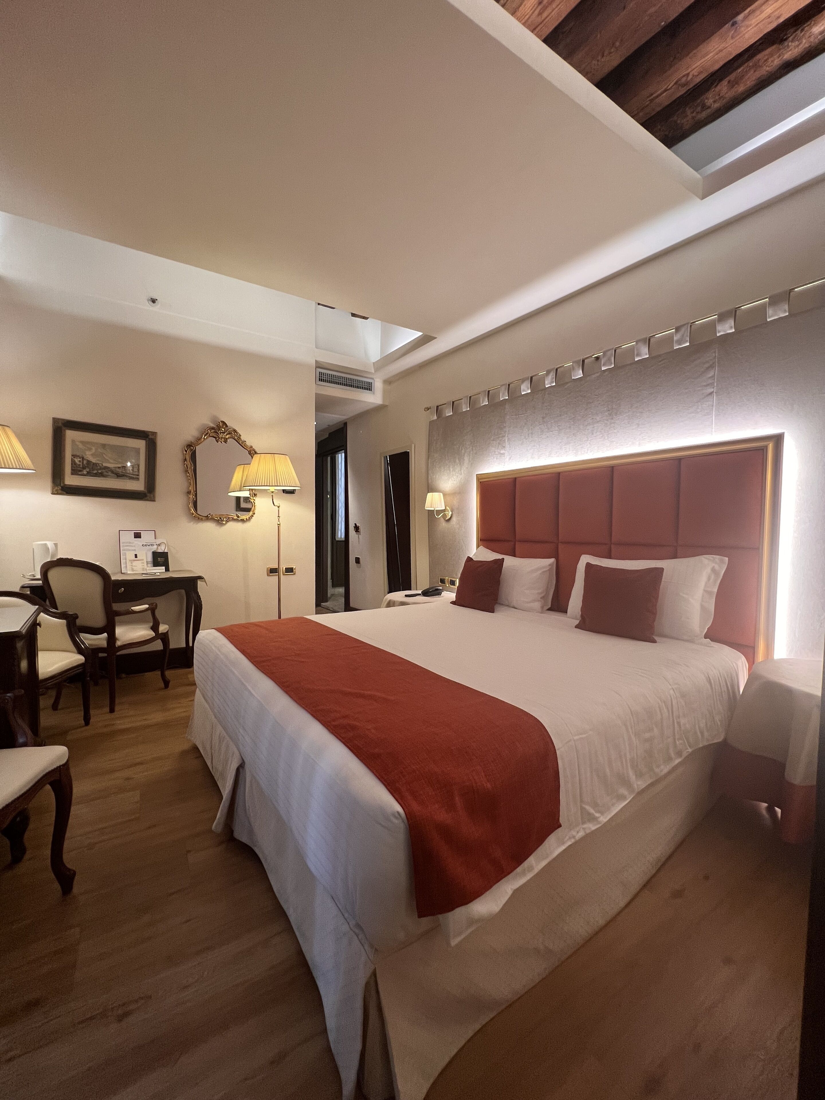 Una habitación de hotel con una cama grande, un escritorio y una silla.