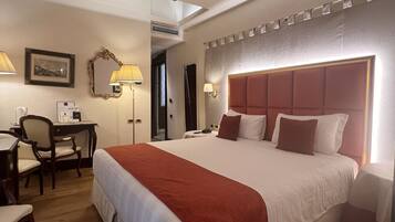 Una habitación de hotel con una cama grande, un escritorio y una silla.
