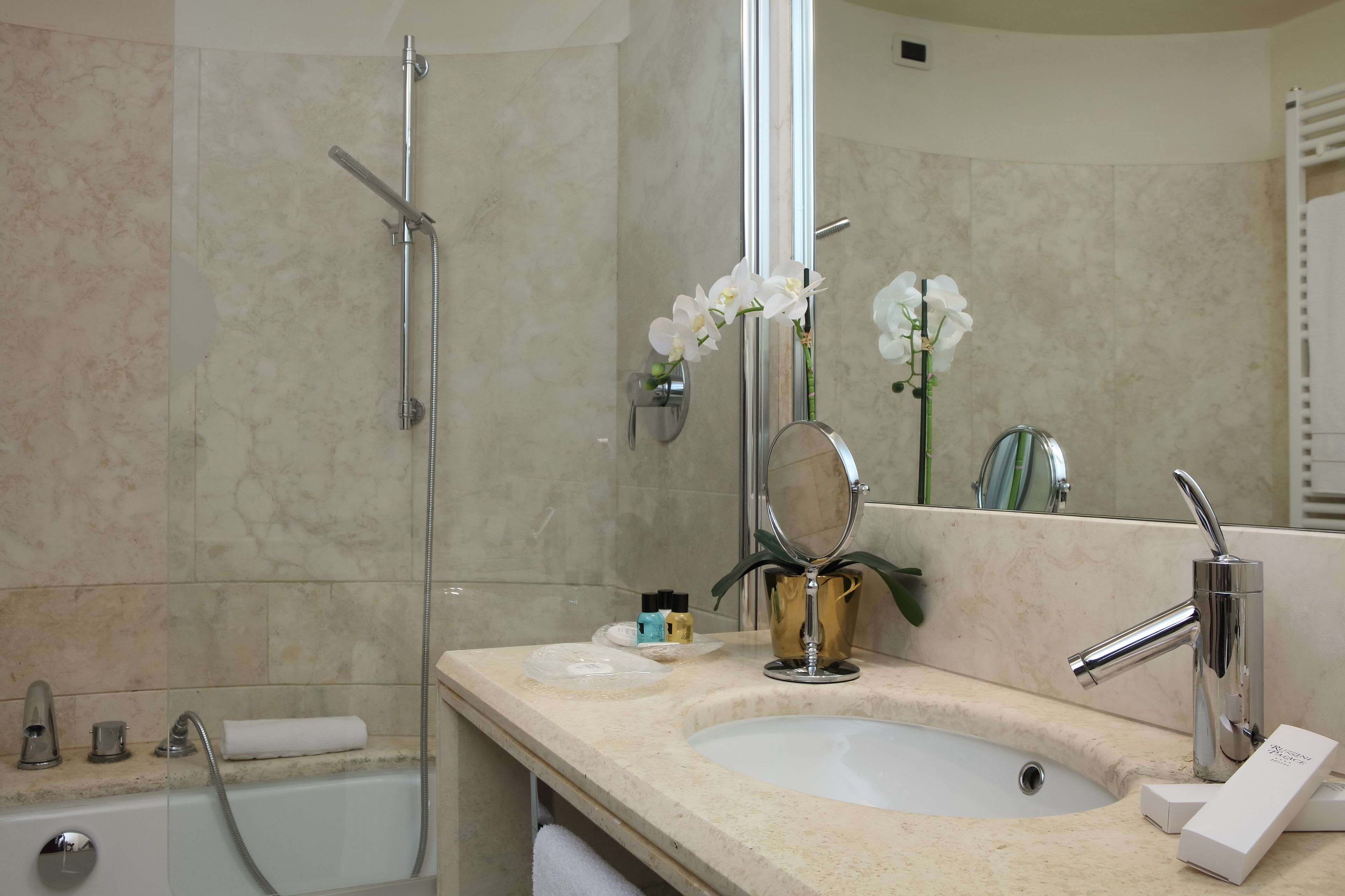 A bathroom with a bathtub, a sink, a mirror, and a shower.