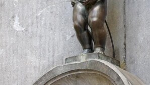 A bronze statue of a child on a pedestal with ornate carvings. - Hotel The Moon (Brussels)