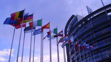 Un edificio con varias banderas en mástiles, que indica un lugar de importancia internacional.