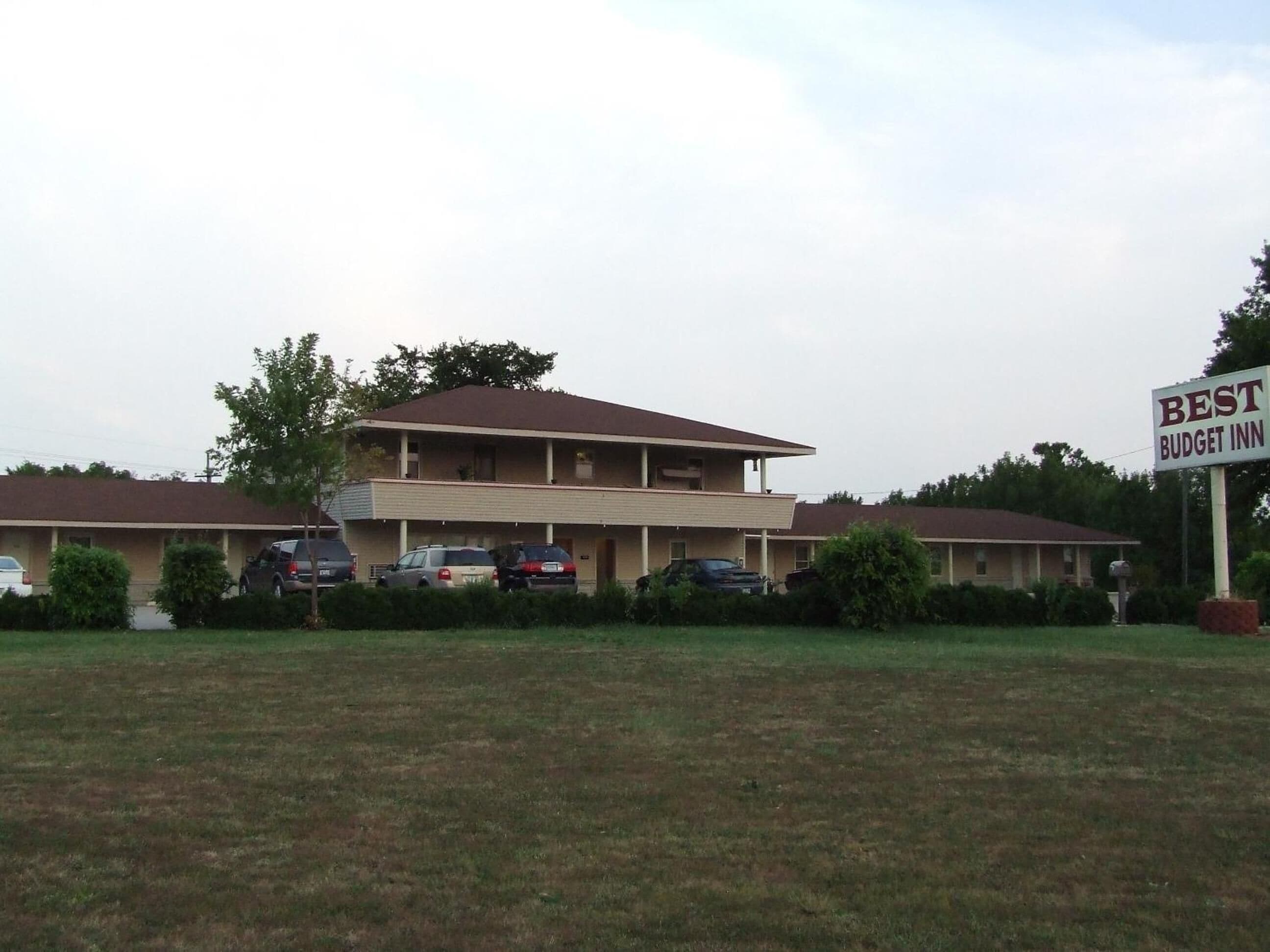 Un motel de dos pisos con un letrero que dice "BEST BUDGET INN".