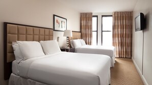 A hotel room with two beds, a TV, a lamp, and a window with curtains. - The Hotel 91 (New York)