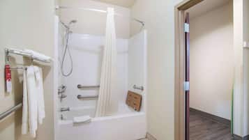 A bathroom with a bathtub, a shower, and a towel rack.