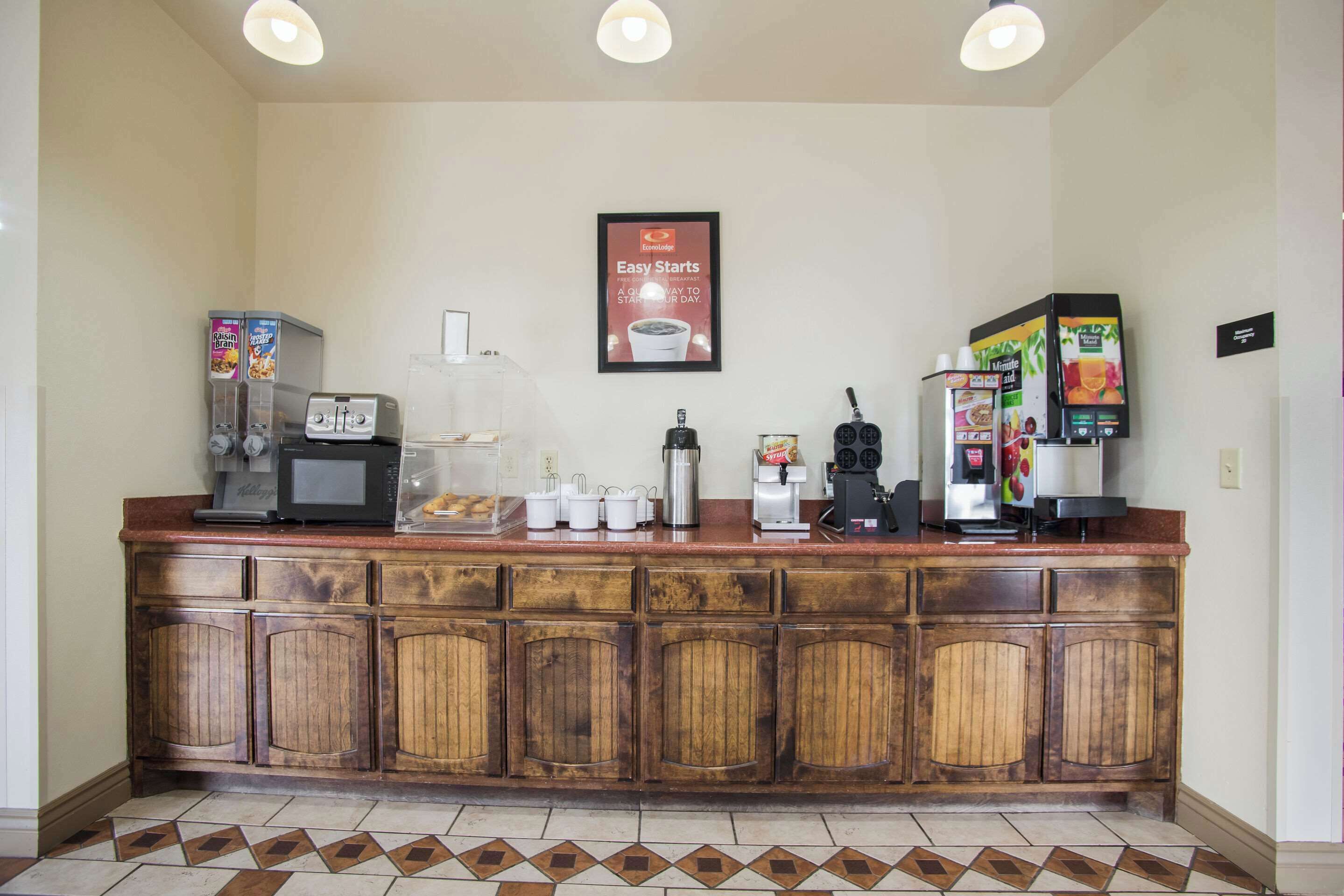 Un área de cocina con estación de café, microondas, tostadora y diversos electrodomésticos.