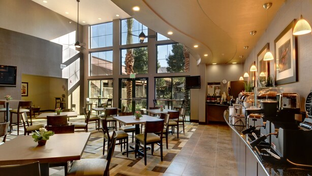 A spacious restaurant with high ceilings, large windows, and a modern bar area. - Wingate by Wyndham St. George (St. George)