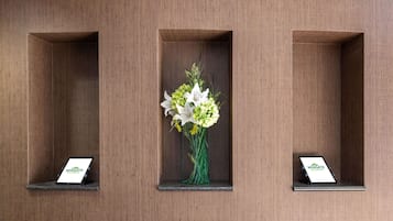 Trois vitrines rectangulaires, chacune contenant un arrangement floral et une tablette.